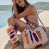 Woman using a wayuu clutch bag with goldfish design